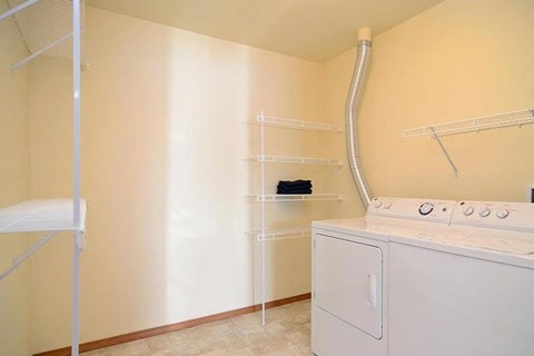 A white washing machine and dryer in a small laundry room.