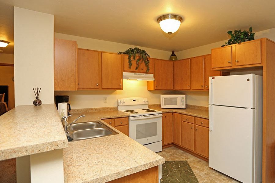 A kitchen with wooden cabinets and a white refrigerator.
