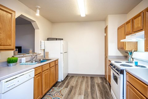 A small kitchen with wooden cabinets and white appliances.