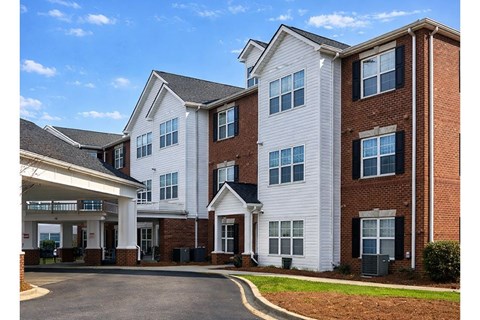 A large white and brick building with a covered walkway.