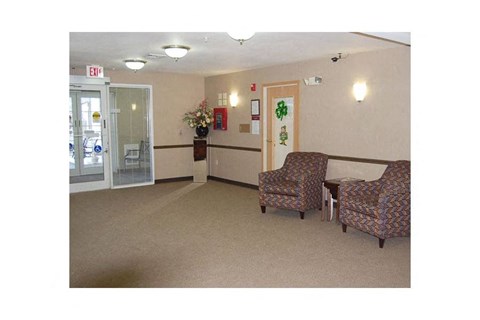 A waiting room with two chairs and a table.