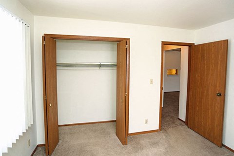 A room with a carpeted floor and two open doors.