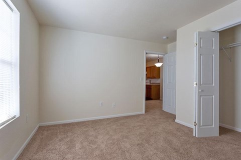 A room with a carpeted floor and a doorway leading to another room.