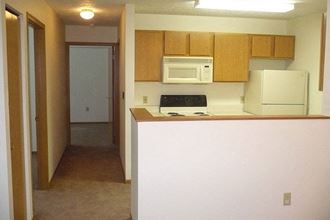 an empty kitchen with a microwave and a refrigerator