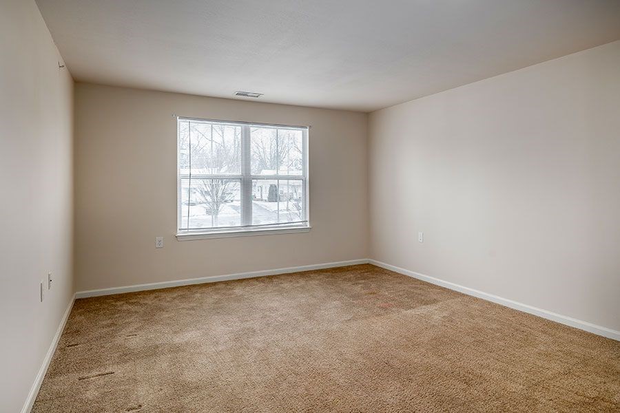 Empty room with carpeted floor and a window.