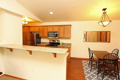 a kitchen with a bar and a table with chairs