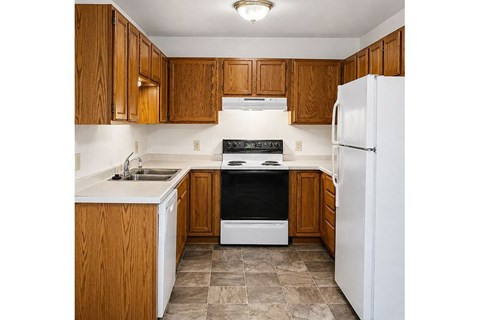 A kitchen with wooden cabinets and a white refrigerator.