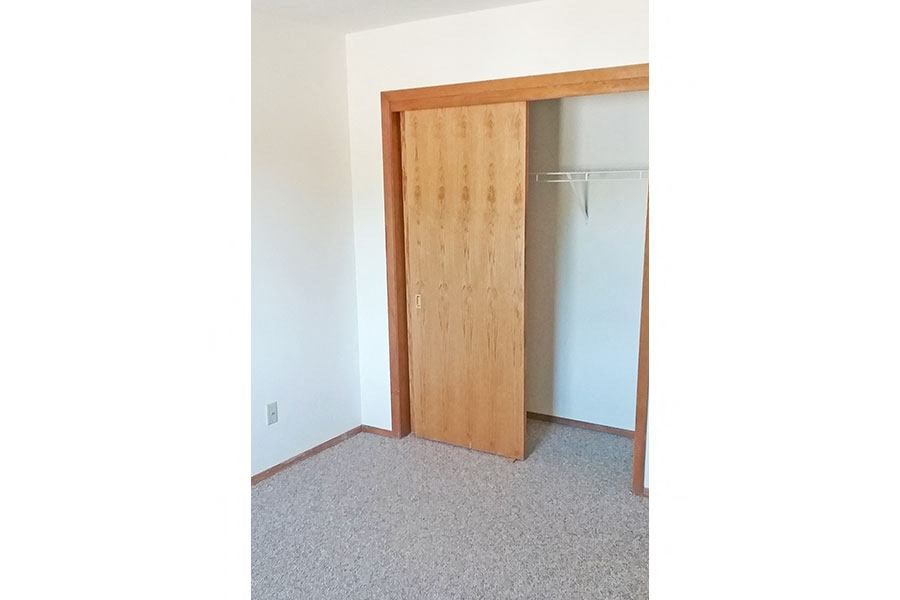 an empty room with a door to a closet