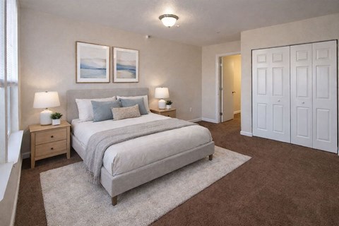 A bedroom with a large bed and two lamps.