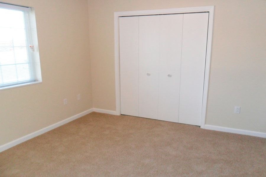 an empty room with a closet and a window