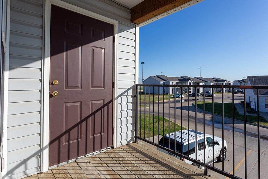 a door to a house with a car parked next to it