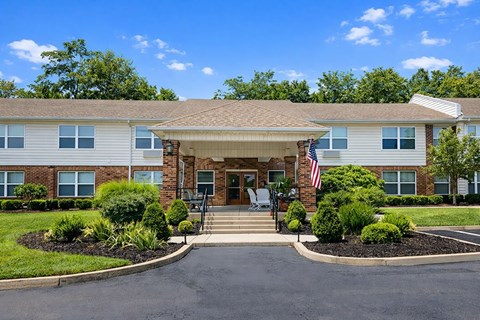 A building with a flag on the front and a driveway leading to the entrance.