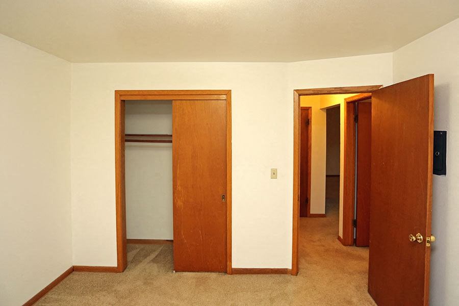 an empty room with three doors and a closet