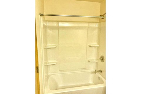 a white bathroom with a shower and a sink