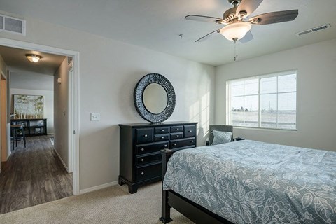 a bedroom with a bed and a ceiling fan