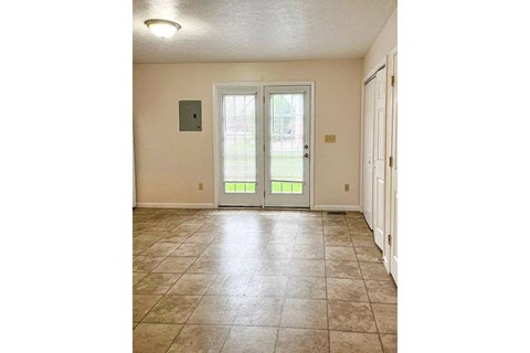 a living room with a door and a tile floor