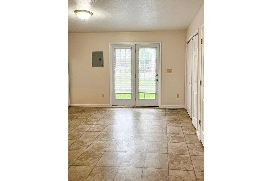 a living room with a door and a tile floor