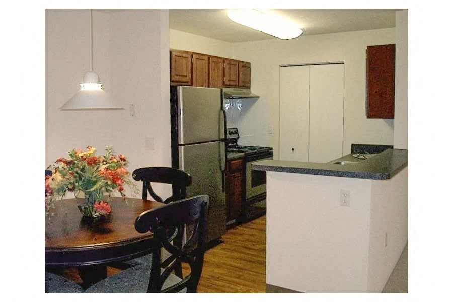 a kitchen with a table and chairs and a refrigerator