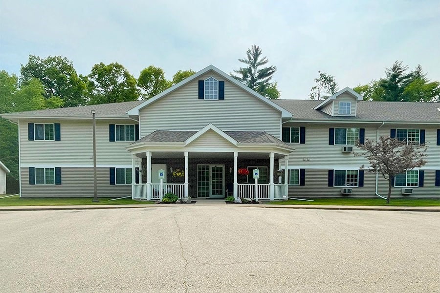 a large white house with a porch and a driveway