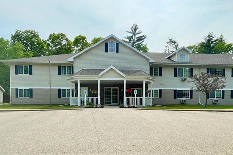 a large white house with a porch and a driveway