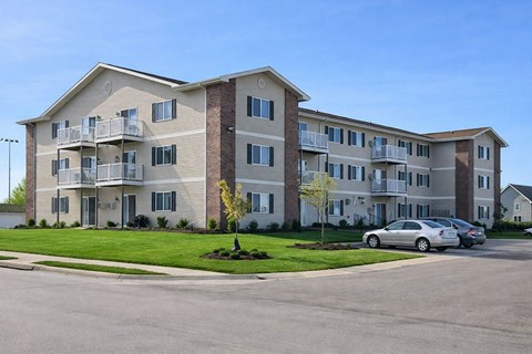 Apartment building with a car parked in front.
