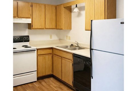 A kitchen with wooden cabinets and white appliances.