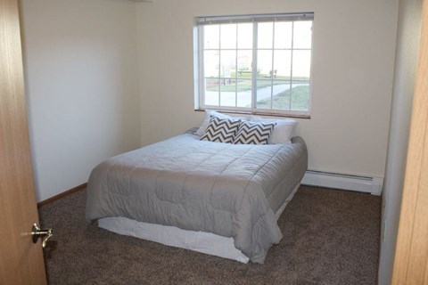 a small bedroom with a bed and a window
