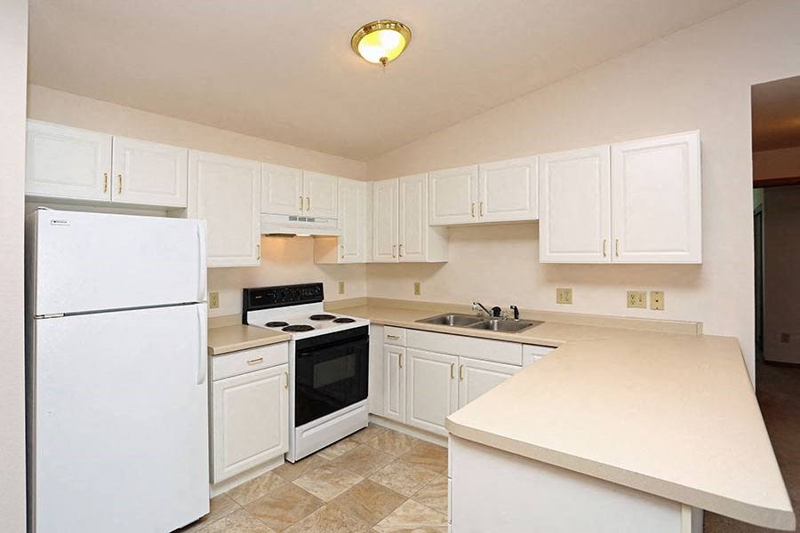 a kitchen with white cabinets and a stove and refrigerator