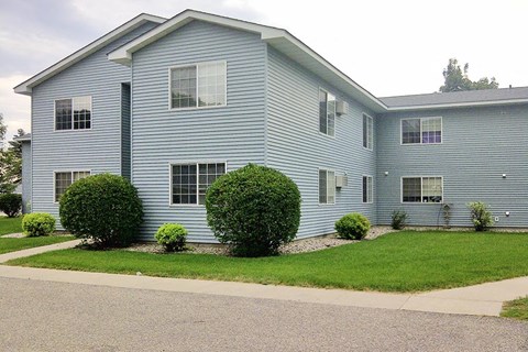 a blue house with a lawn in front of it