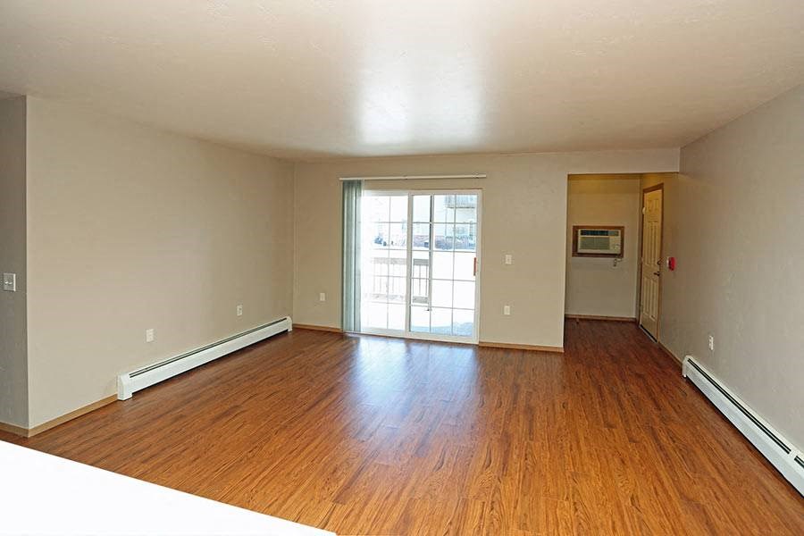 an empty living room with wood floors and a door