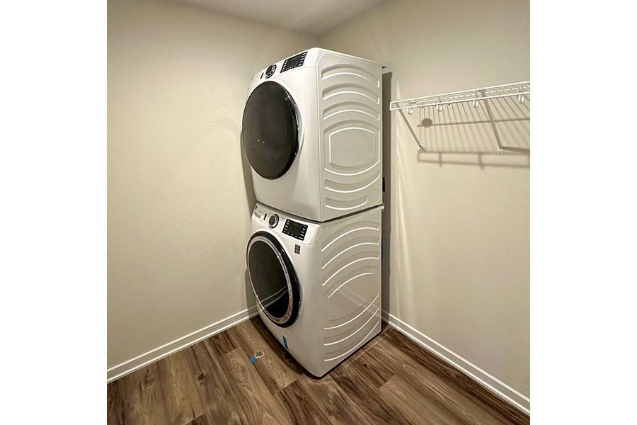 A white stacked washer and dryer in a laundry room.