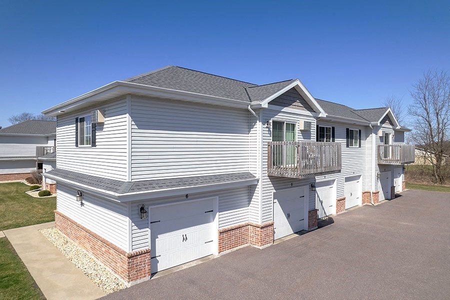 a white house with a balcony and a driveway