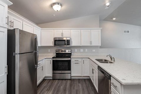 a kitchen with stainless steel appliances and white cabinets