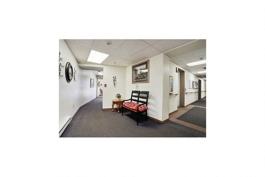 a hallway with a chair and a table in a building