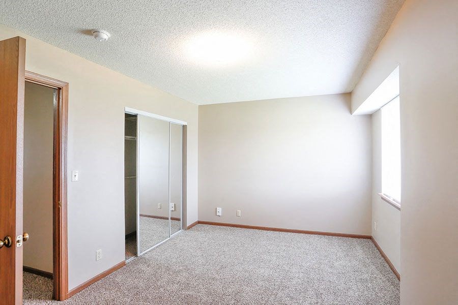 an empty room with a mirror and a closet