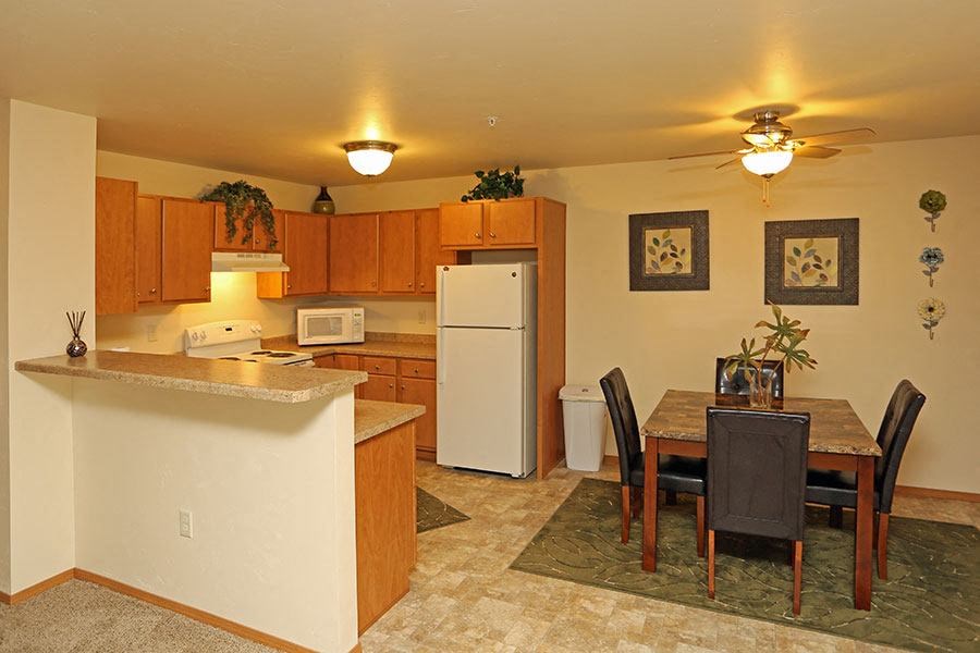 A kitchen with a table and chairs.