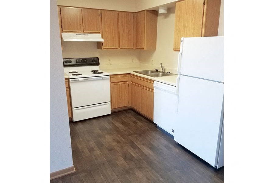 A kitchen with a white refrigerator, white stove, and white oven.