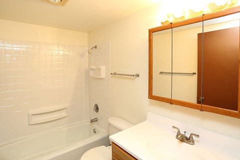 A white bathroom with a white tub and sink.