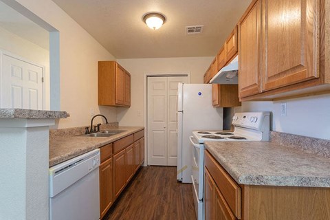 A kitchen with wooden cabinets and a white fridge.