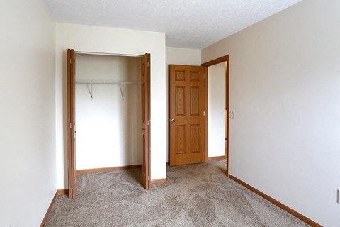 an empty room with a closet and a door
