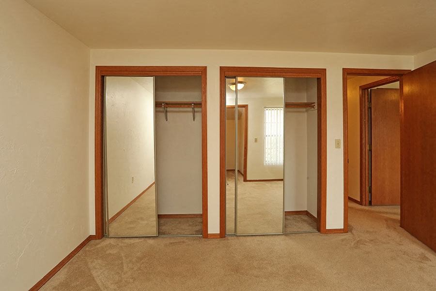 A hallway with three doors and a carpeted floor.