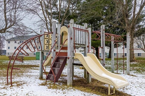 A playground with a slide and a climbing frame.