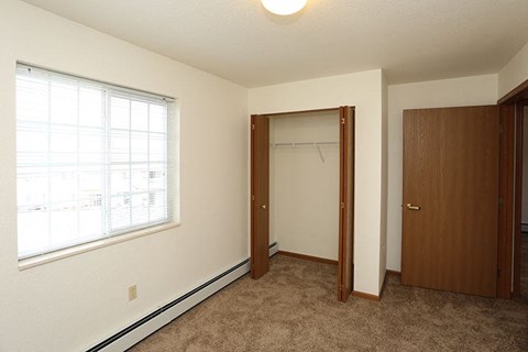 a bedroom with a large window and a closet