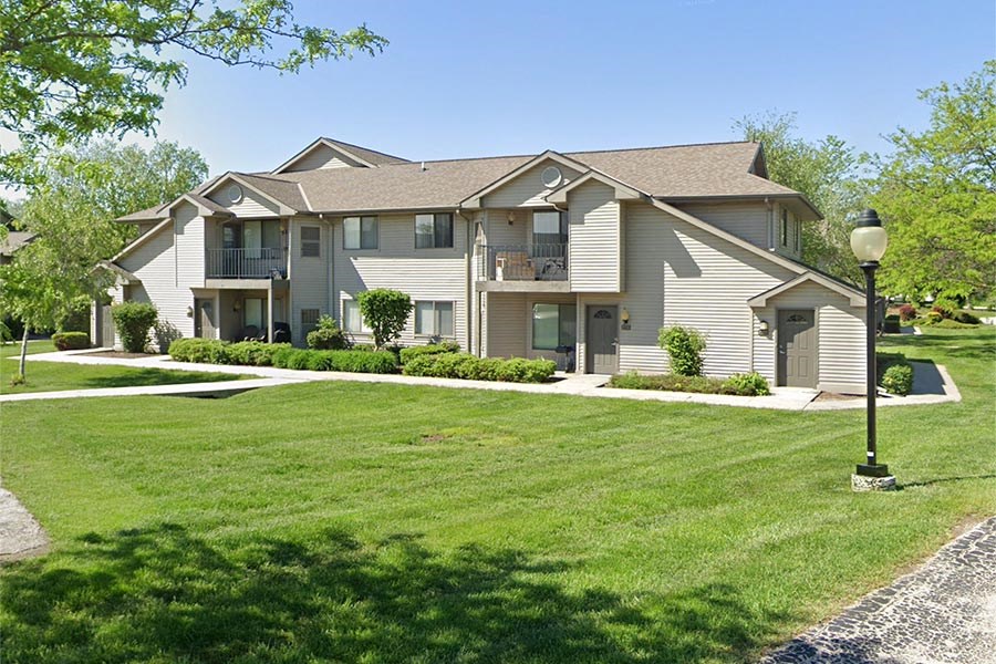 a house with a lawn and a lamp post in front of it