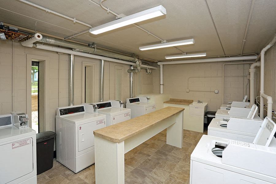 an empty room with many white washing machines