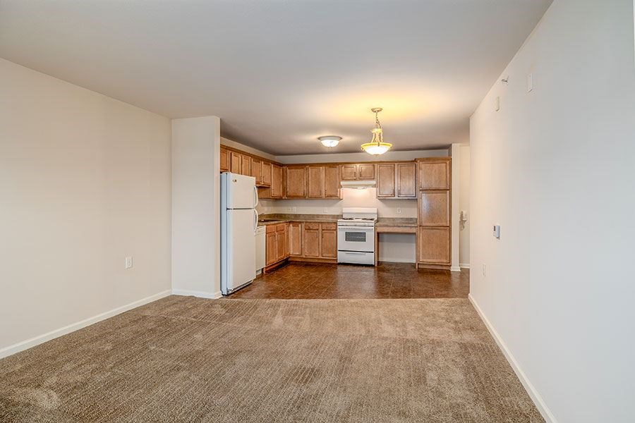A kitchen with white appliances and wooden cabinets.