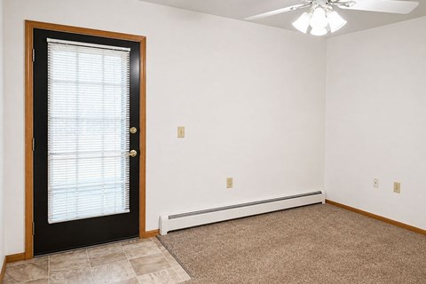 A room with a black door and a ceiling fan.