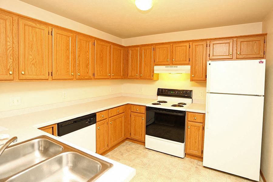 a kitchen with white appliances and wooden cabinets