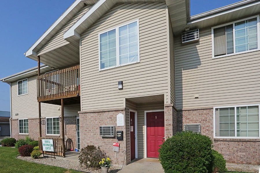 an apartment building with a red door and a balcony