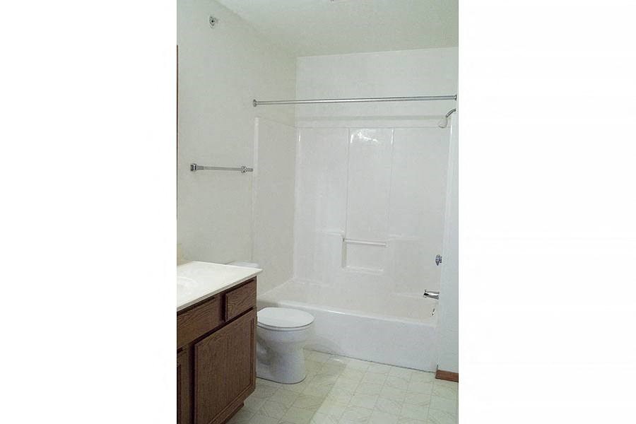 a white bathroom with a shower and a toilet